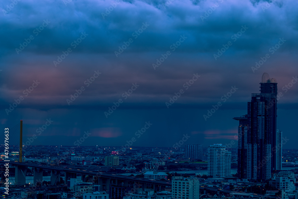 Fototapeta premium The high angle background of the city view with the secret light of the evening, blurring of night lights, showing the distribution of condominiums, dense homes in the capital community