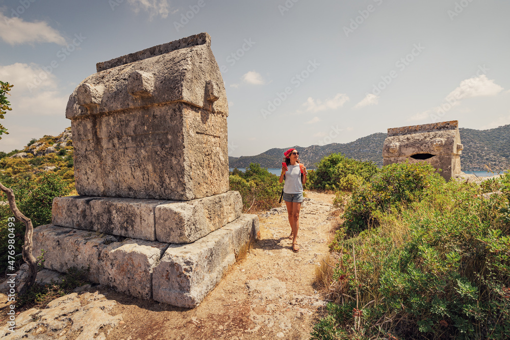 Φωτογραφία Girl traveler exploring ancient ruins of Lycian necropolis city with fascinating Tombs and sarcophagus near Kekova island in Turkey