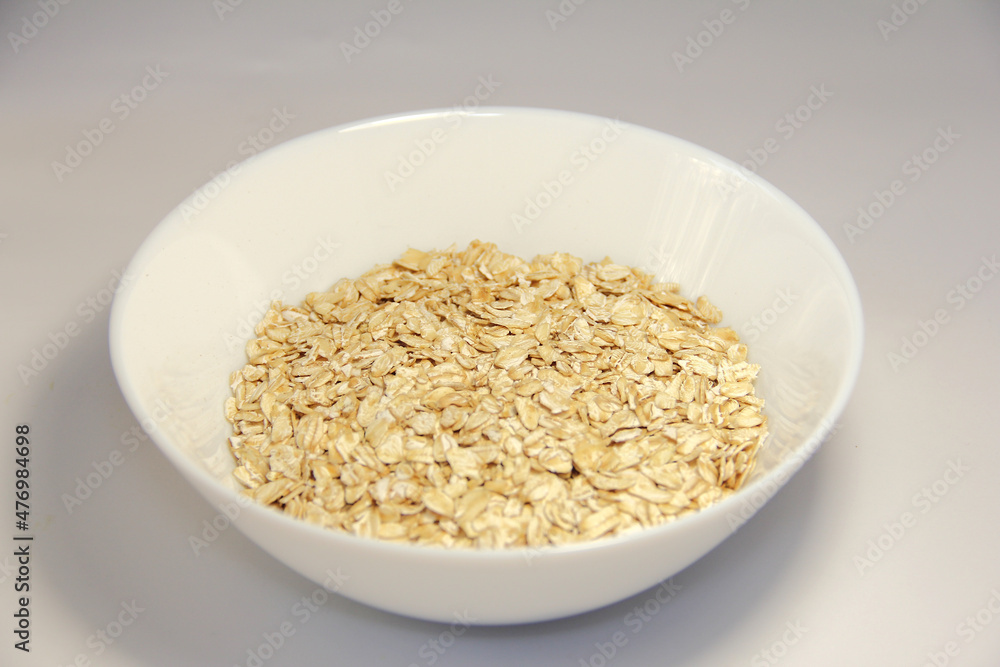 Oatmeal in a white bowl. On a white background. Oatmeal in a white bowl. On a white background.
