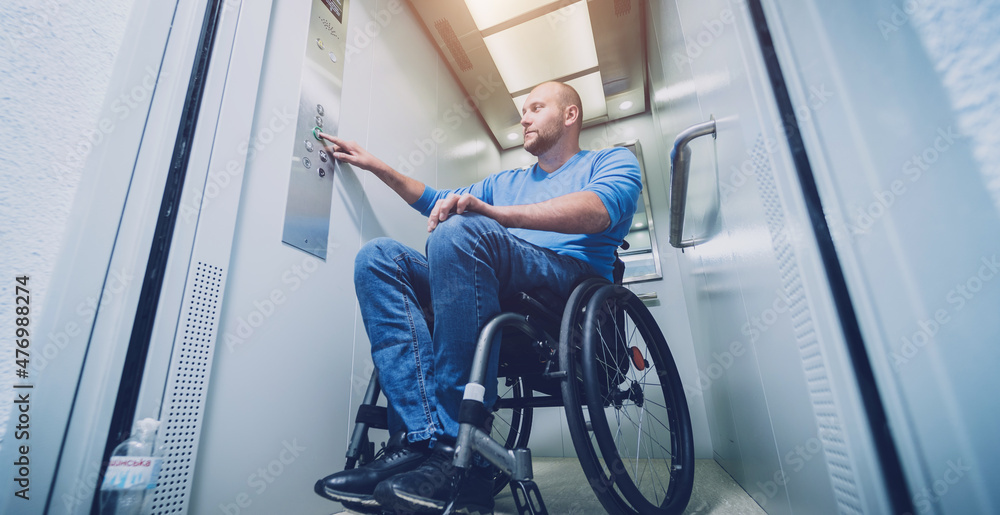 Person with a physical disability who uses wheelchair using lift in building Person with a physical disability who uses wheelchair using lift in building