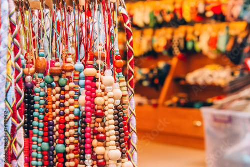Souvenir stall with variety of colorful souvenirs - wooden beads bracelets and amulets, street souvenir market. Popular touristic present. Selective focus