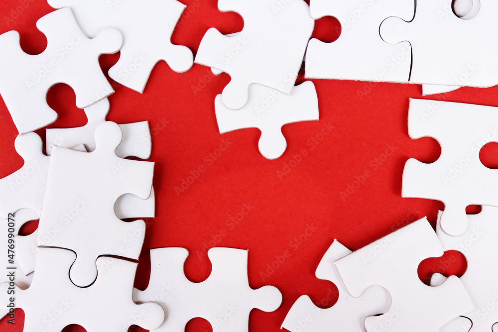 White puzzle pieces on red background, copy space for text. White puzzle pieces on red background, copy space for text.