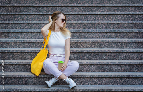 Young beautiful woman with linen eco bag on stairs background.