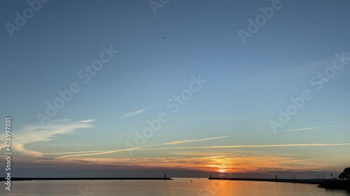 TILT SHOT SLOW MOTION - Lighthouses at the Douro River Mouth (Foz do Douro), Porto, Portugal. The North jetty at Barra do Douro on the north bank, Felgueiras and Pontao Lighthouses at sunset. photo