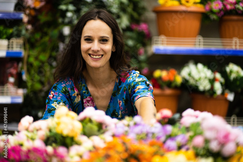 Beauty woman in a florist store smiling at the camera