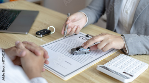 Selling cars, Car dealership or sales manager offers the sale of a car and explains the terms of signing a car purchase and insurance contract, Finance and after-sales service concept. .