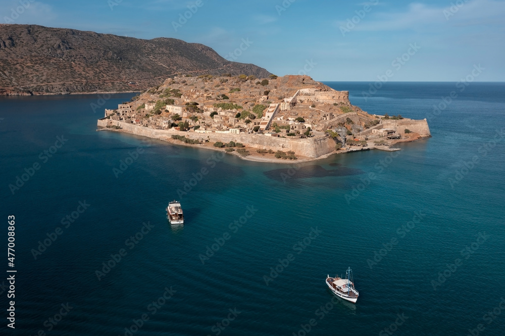 Aerial view of Spinalonga island with ancient fortifications and buildings behind the wall, Greece