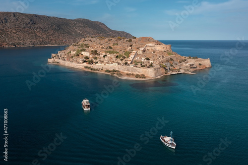 Aerial view of Spinalonga island with ancient fortifications and buildings behind the wall, Greece