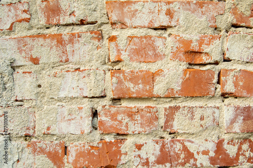 Wall of old red bricks and cement plaster