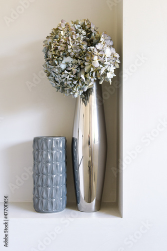 Calm dry flowers bunch in a silver grey vase in a recessed wall