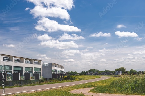 Obraz na płótnie Sunny summer day at Netherlands suburb. Modern architecture residential houses and green nature across the road. w salonie