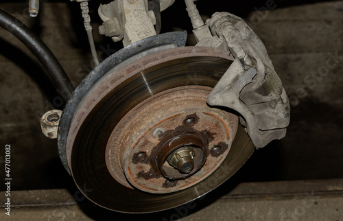 The brake disc of the front suspension during the repair close-up. fuzzy focus