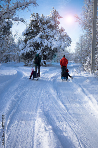 dads take their children to ride on the snow slides. sledges, fun, boy, girl