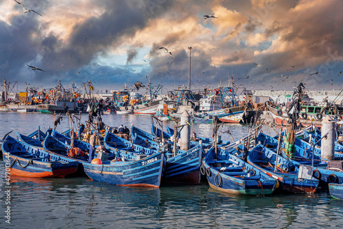 Essaouira, Morocco. October 10, 2021. Small fishing boats moored on coast at port against cloudy sky, Wooden fishing boats moored in harbor