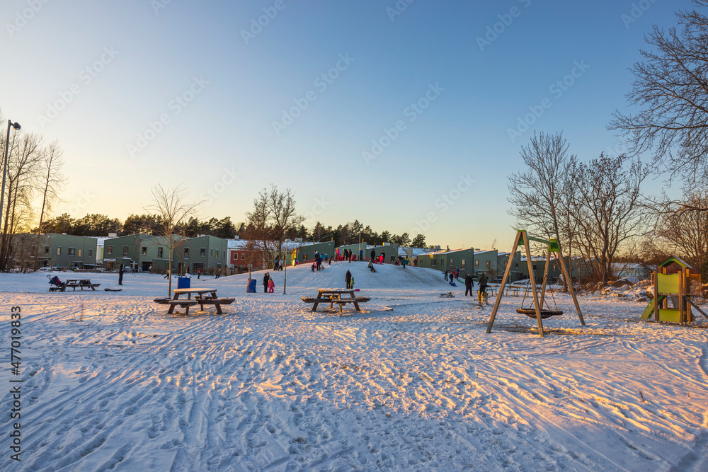 Beautiful view of people on outdoor playground on sunny cold winter day. Sweden. 
