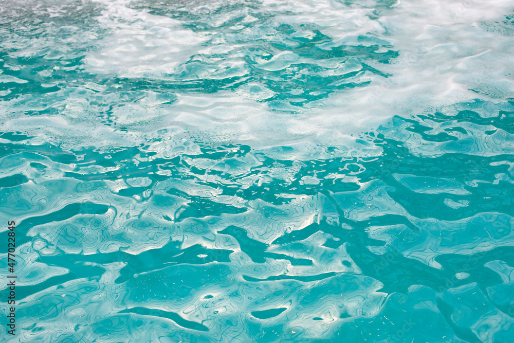 Textured water surface with waves and foam, clear blue pool water Textured water surface with waves and foam, clear blue pool water