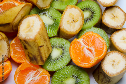 Fototapeta banana, kiwi and tangerines on a white background, healthy eating, vegetarianism