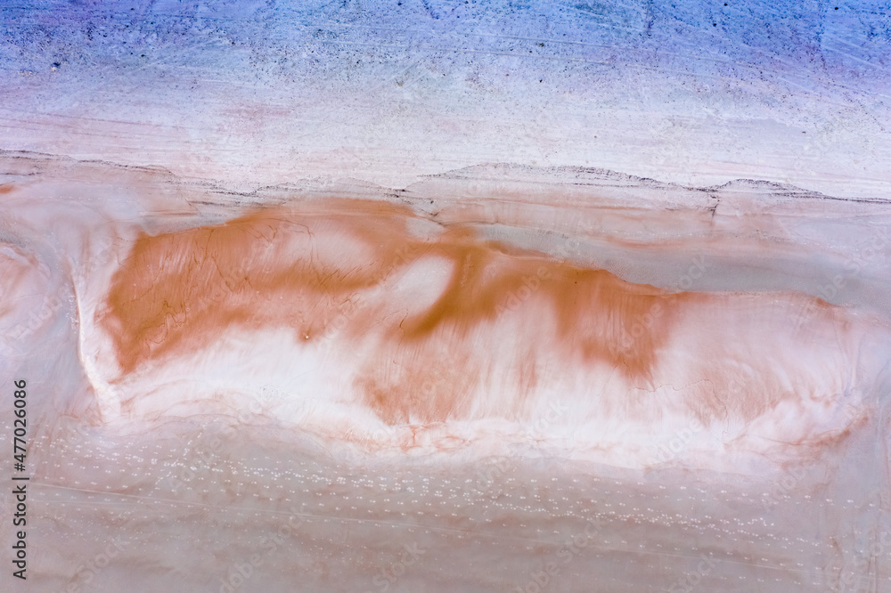 Fototapeta premium Early morning beautiful top down aerial of beach sand pattern that looks like a sleeping fox and a line of foot prints crossing the sand