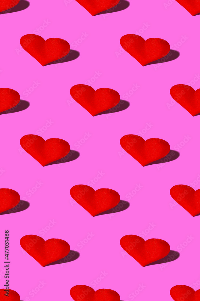 Red heart with a hard shadow on a pink background. Seamless patterns. Celebrating Valentine's Day copy space. Vertical format
