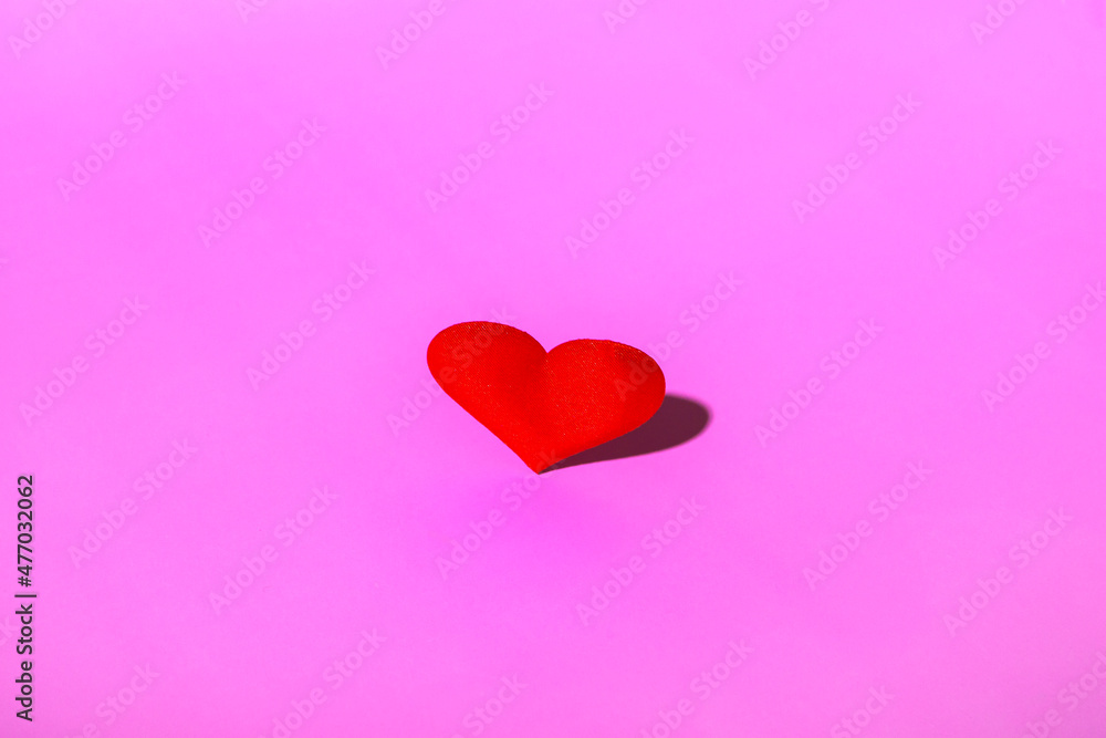 Red heart on a pink background copy space. Minimalistic valentine's day concept