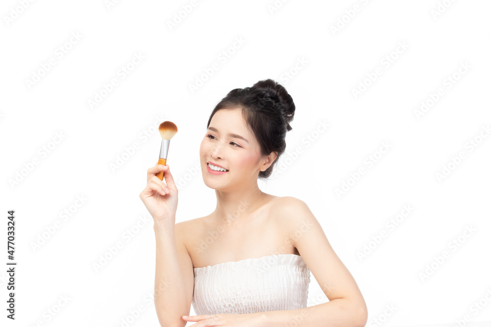 Closeup portrait of beautiful happy young girl holding brush near face isolated on white background. Beauty and cosmetics concept. Closeup portrait of beautiful happy young girl holding brush near face isolated on white background. Beauty and cosmetics concept.