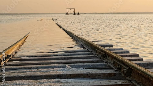 Old train rides on the railway laid in the water through the salt lake. train travels from water. Mined salt in Lake Burlin. Altai. Bursol. Russia. August 2019 