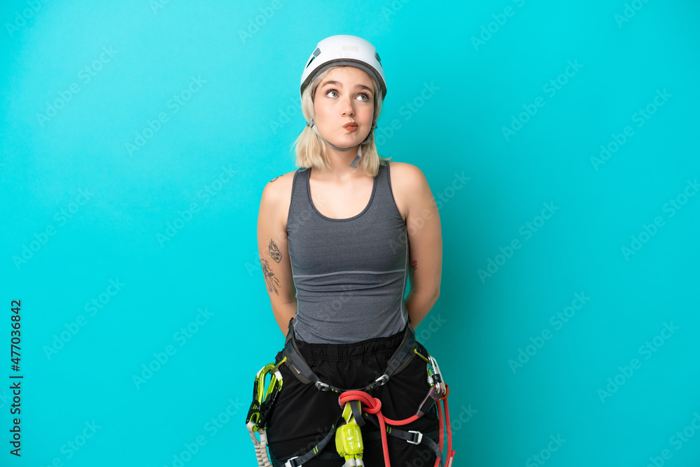 Young caucasian rock-climber woman isolated on white background and looking up Young caucasian rock-climber woman isolated on white background and looking up