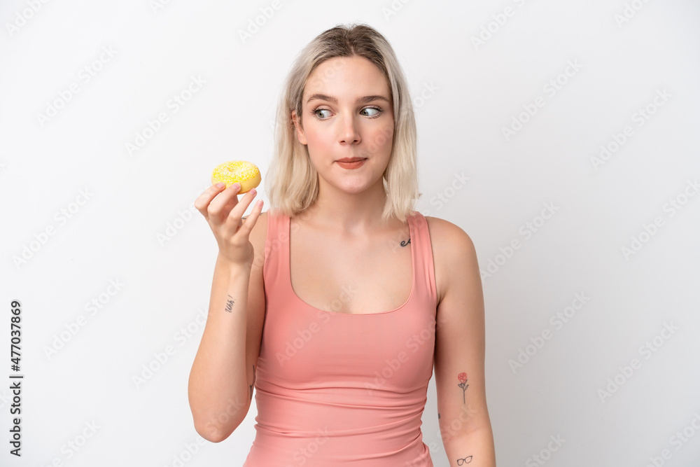 Young caucasian woman isolated on white background holding a donut Young caucasian woman isolated on white background holding a donut