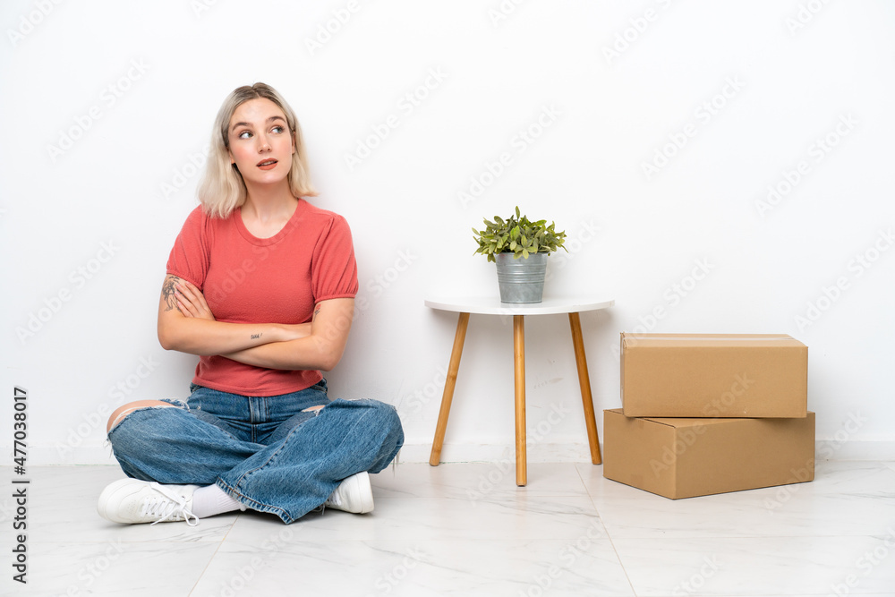 Young woman moving in new home among boxes isolated on white background with arms crossed and happy Young woman moving in new home among boxes isolated on white background with arms crossed and happy