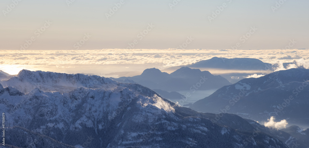 Aerial Panoramic View of Canadian Mountain covered in snow during sunny winter evening. Located near Squamish, North of Vancouver, British Columbia, Canada. Nature Background Panorama