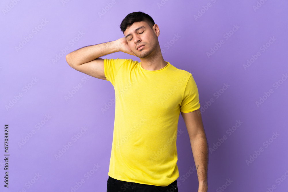 Young Colombian man isolated on purple background with neckache Young Colombian man isolated on purple background with neckache