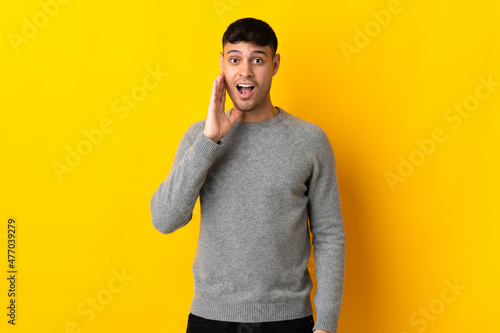 Young Colombian man isolated on yellow background with surprise and shocked facial expression