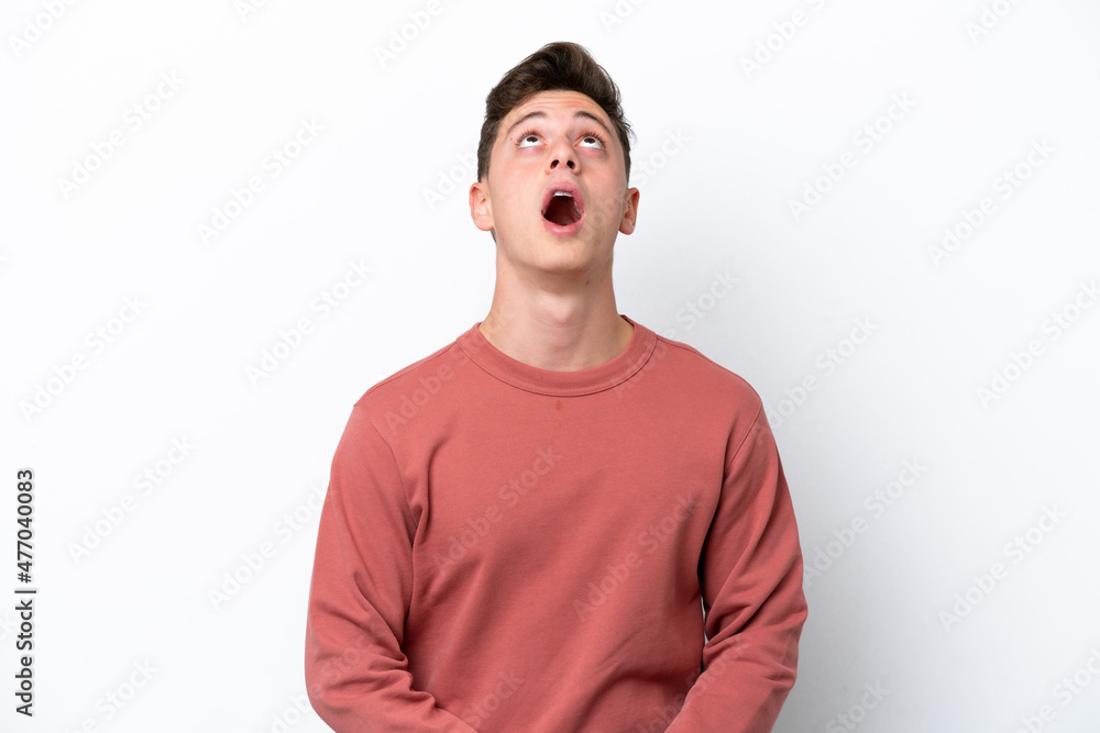 Young handsome Brazilian man isolated on white background looking up and with surprised expression Young handsome Brazilian man isolated on white background looking up and with surprised expression