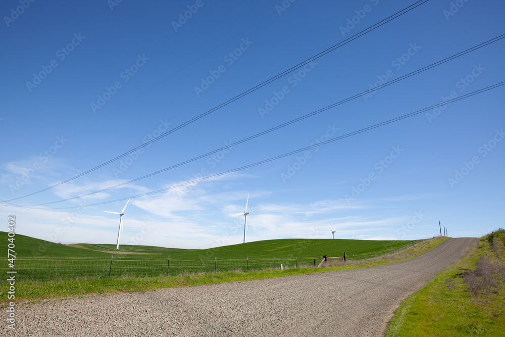 Wind turbines with blue sky and country road