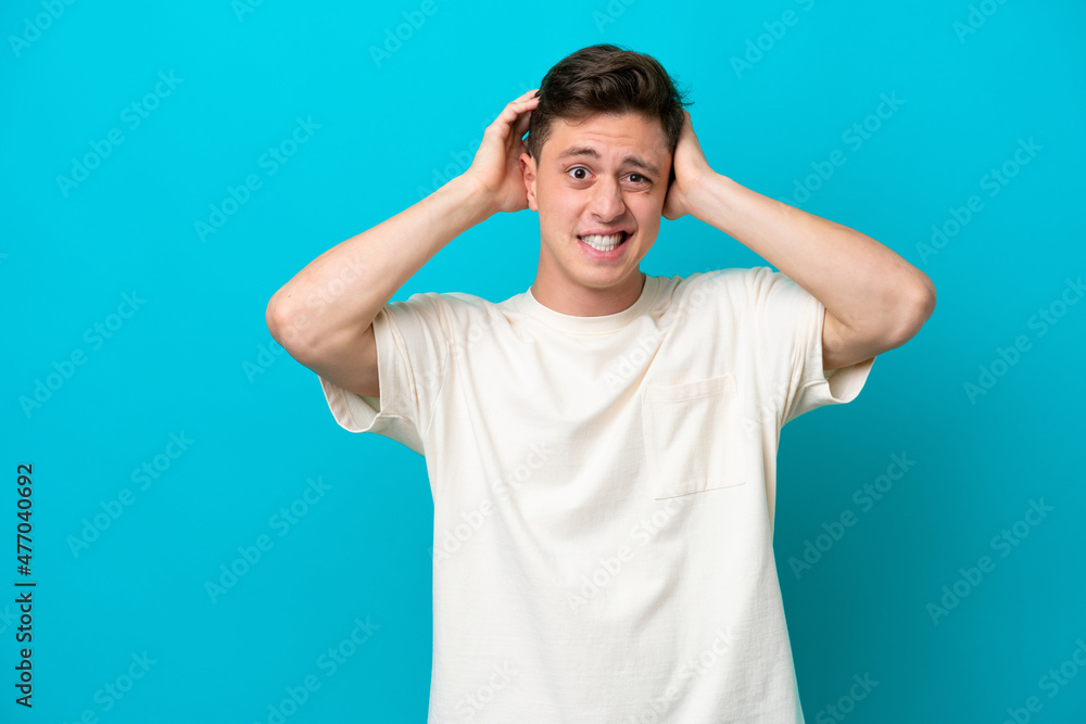 Young handsome Brazilian man isolated on blue background doing nervous gesture Young handsome Brazilian man isolated on blue background doing nervous gesture