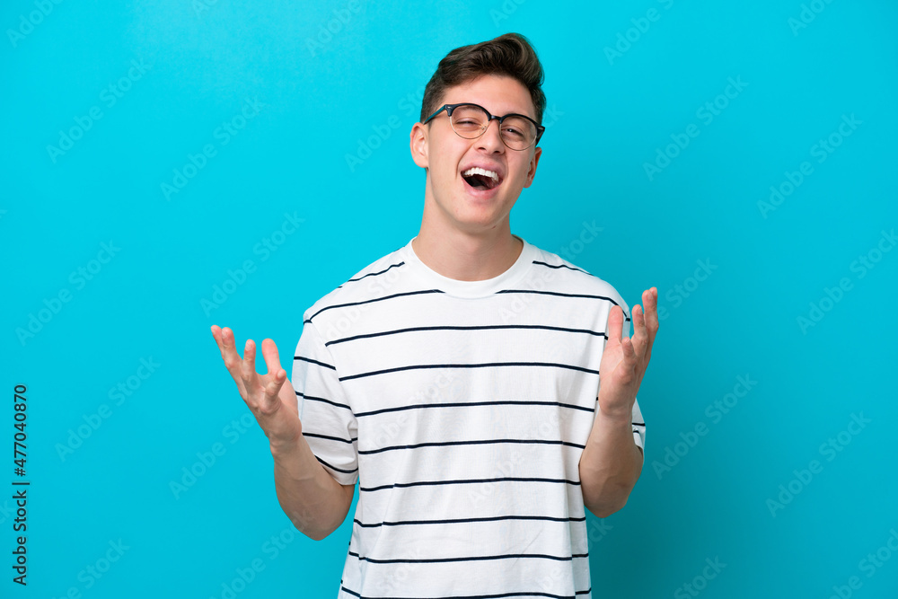 Young handsome Brazilian man isolated on blue background smiling a lot Young handsome Brazilian man isolated on blue background smiling a lot