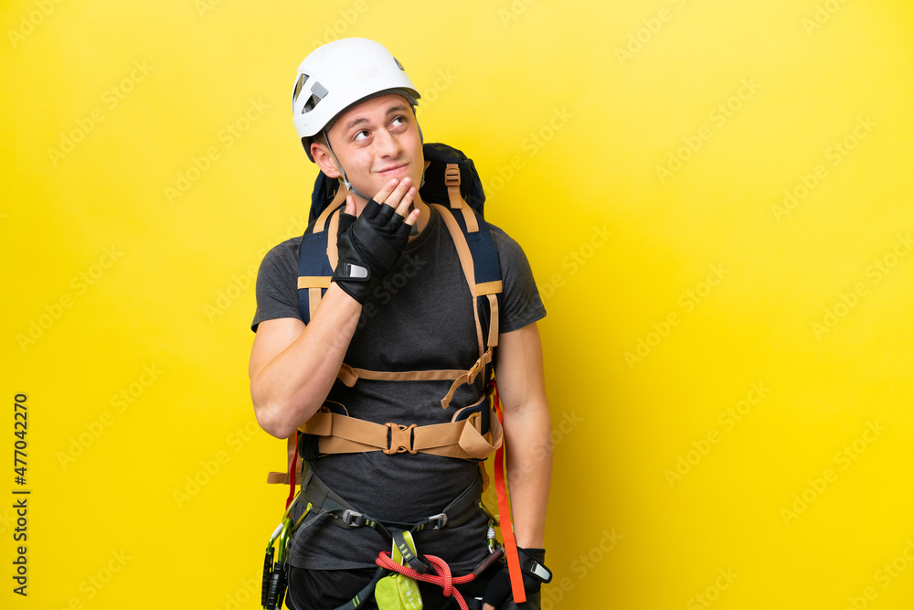 Young rock climber Brazilian man looking up while smiling Young rock climber Brazilian man looking up while smiling