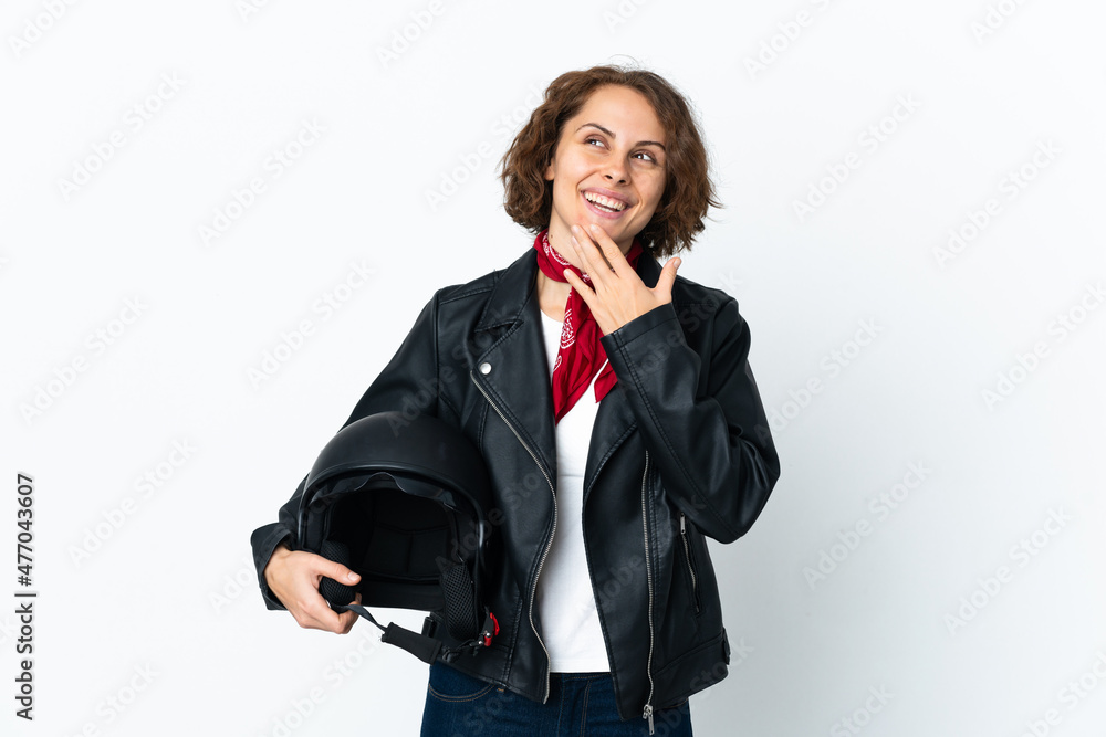 English woman holding a motorcycle helmet isolated on white background looking up while smiling English woman holding a motorcycle helmet isolated on white background looking up while smiling