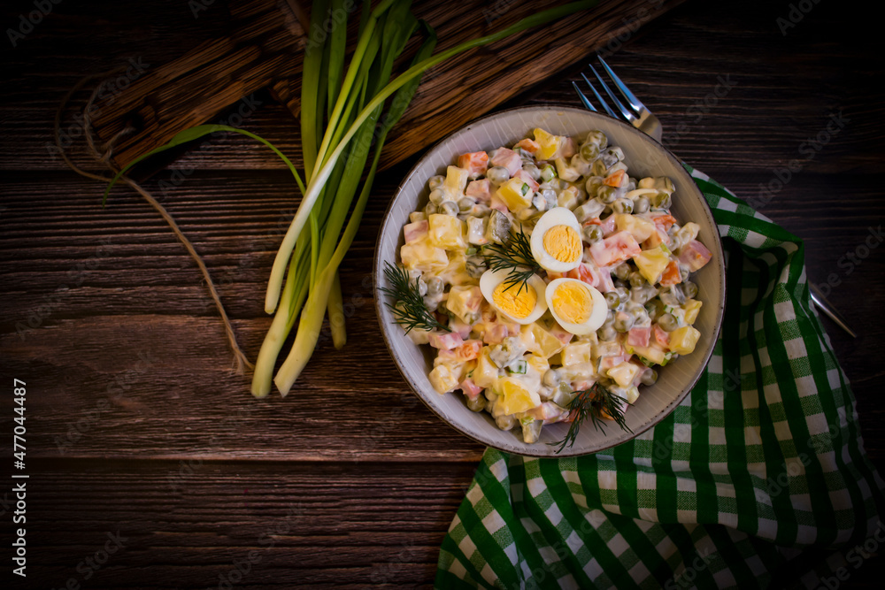 olivier salad, green onions on wooden background olivier salad, green onions on wooden background