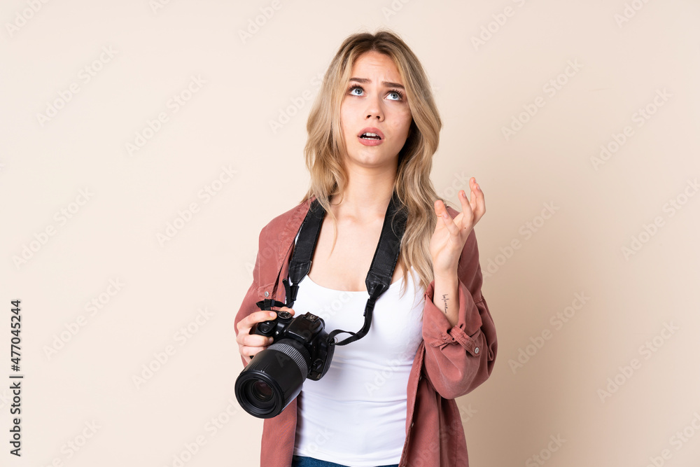 Fototapeta premium Young photographer girl over isolated background frustrated by a bad situation
