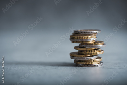 Euro coins stacked on each other. Euro currency on a dark background. Coins fallen because inflation. 