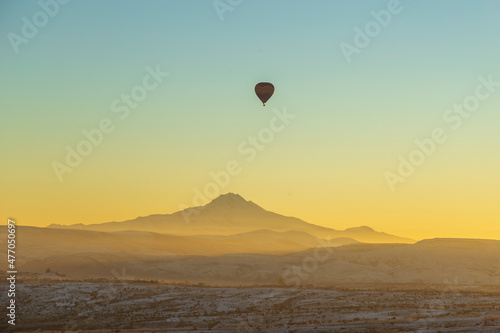 Hot air balloons flying over spectacular Cappadocia. Beautiful view of hot air balloons floating in sunrise blue sky over the mountain landscape of fairy chimneys