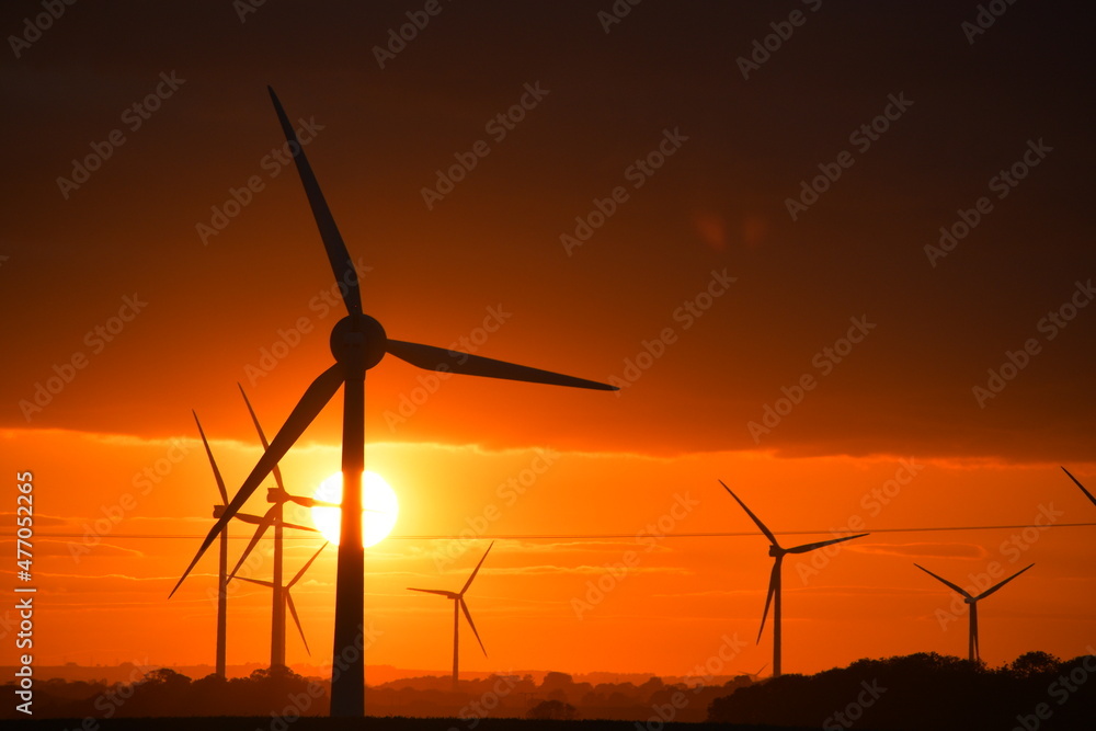 Striking sunset through wind turbine farm in East Yorkshire, UK Striking sunset through wind turbine farm in East Yorkshire, UK
