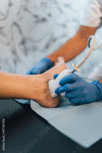 Close-up of a Chiropodist doing an ultrasound test to patient s foot.