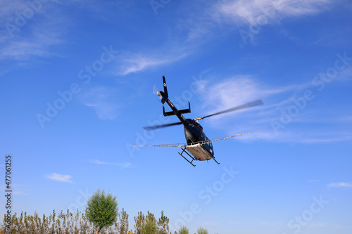an agricultural helicopter flying against American white moth flies from the landing point to the spraying area, North China