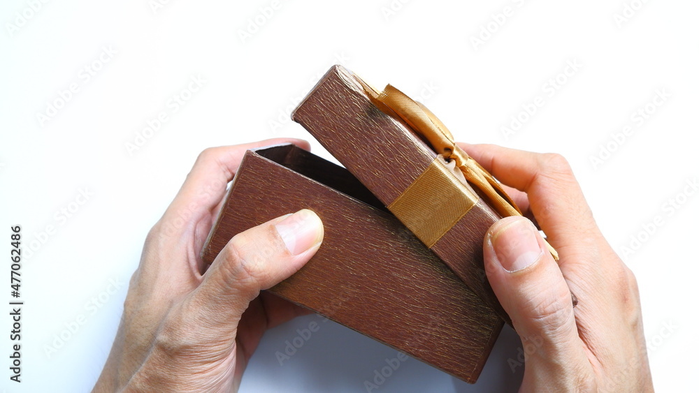 Obraz premium A man's hand gives a gift box with a ribbon on a white background. Valentine concept, New year Concept, Christmas Concept. Top view, Anniversary Concept. High angle view, Flat Lay.