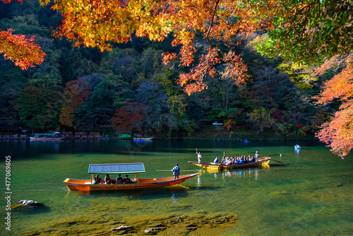 Katsura Tourist Sightseeing Boat cruising along Hozugawa River in Autumn at Arashiyama, Kyoto, Japan