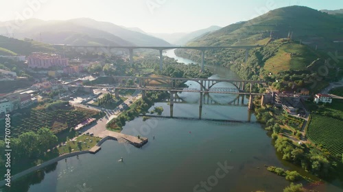 Scenic aerial view of Vila Real District along the Douro Valley River with bridges. Stunning massive Ponte Miguel Torga and Régua Pedestrian Bridge with the beautiful green town by the river in 4K. photo