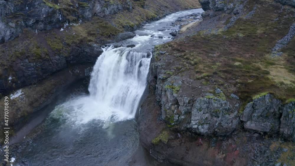 Aerial descending shot of crashing water of waterfall into Selá River - Iceland,Europe Aerial descending shot of crashing water of waterfall into Selá River - Iceland,Europe
