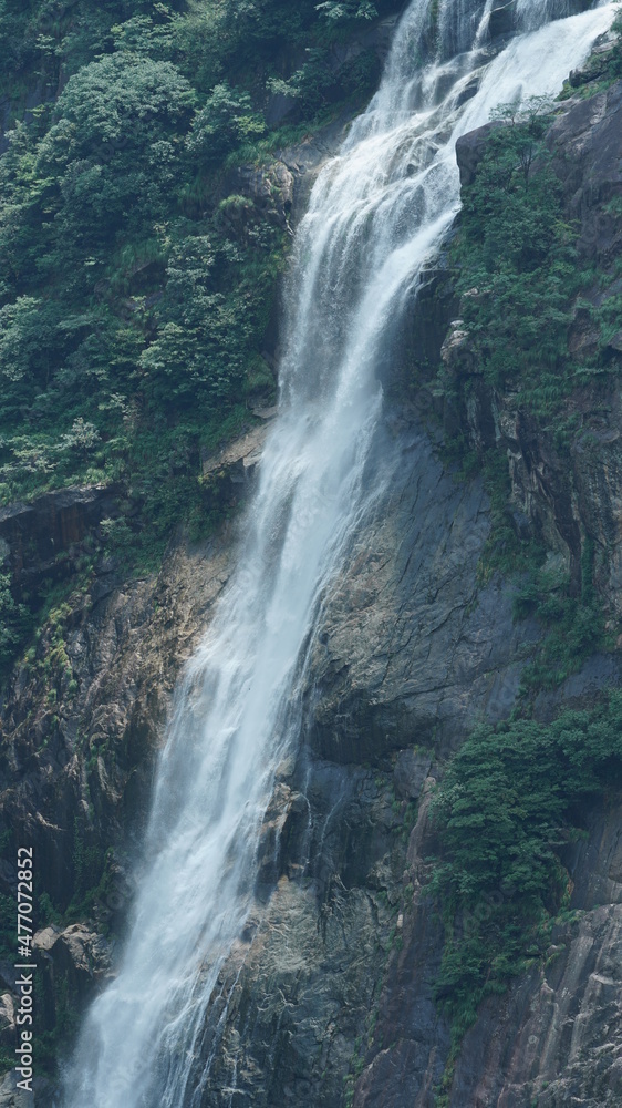 Obraz premium The beautiful countryside view with the waterfall flowing in the mountains after the rainy day